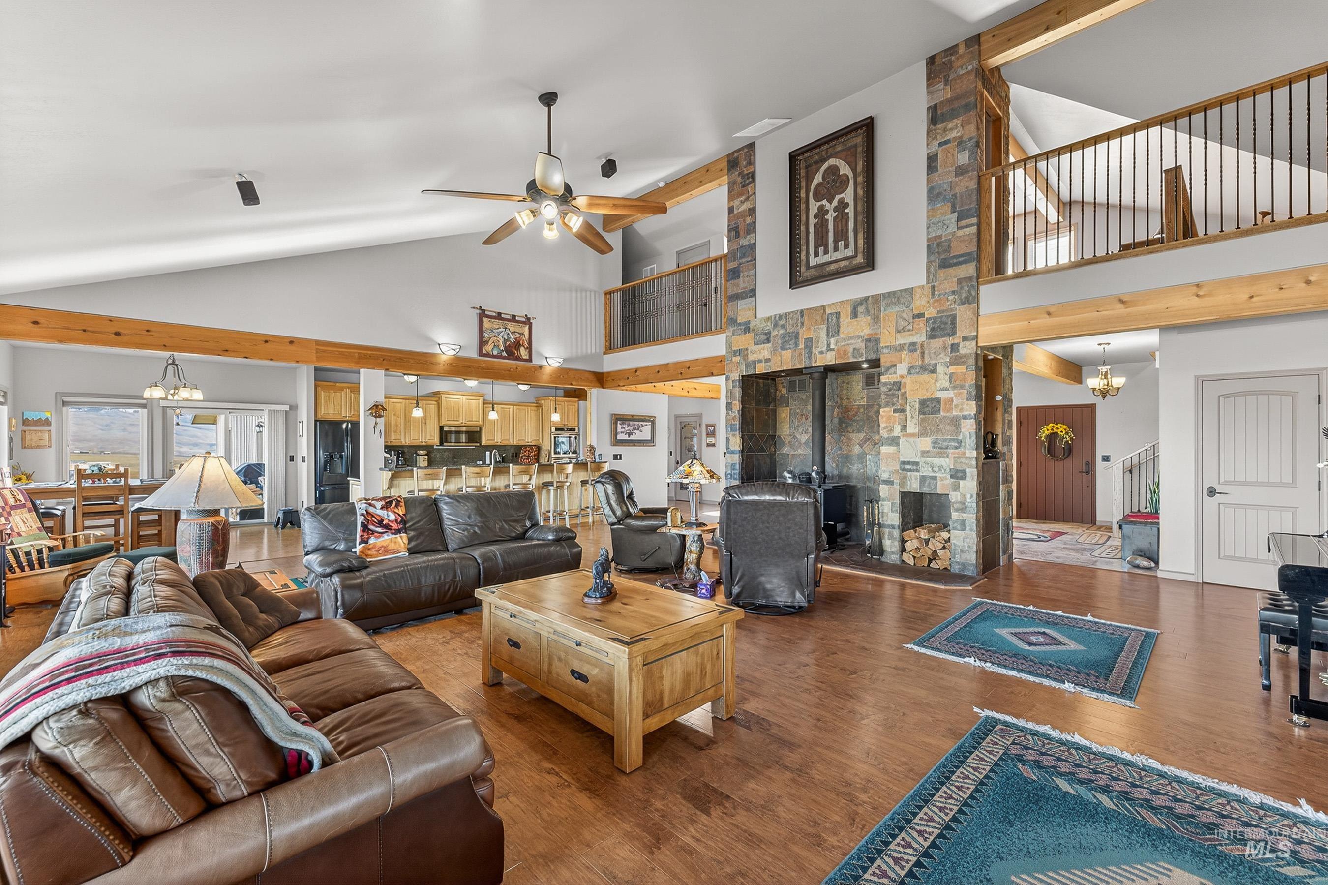 2195 Kilborn Lane Mesa, ID 83643 - Photo 14 of 50 Living room featuring a chandelier, high vaulted ceiling, wood finished floors, a ceiling fan, and a wood stove