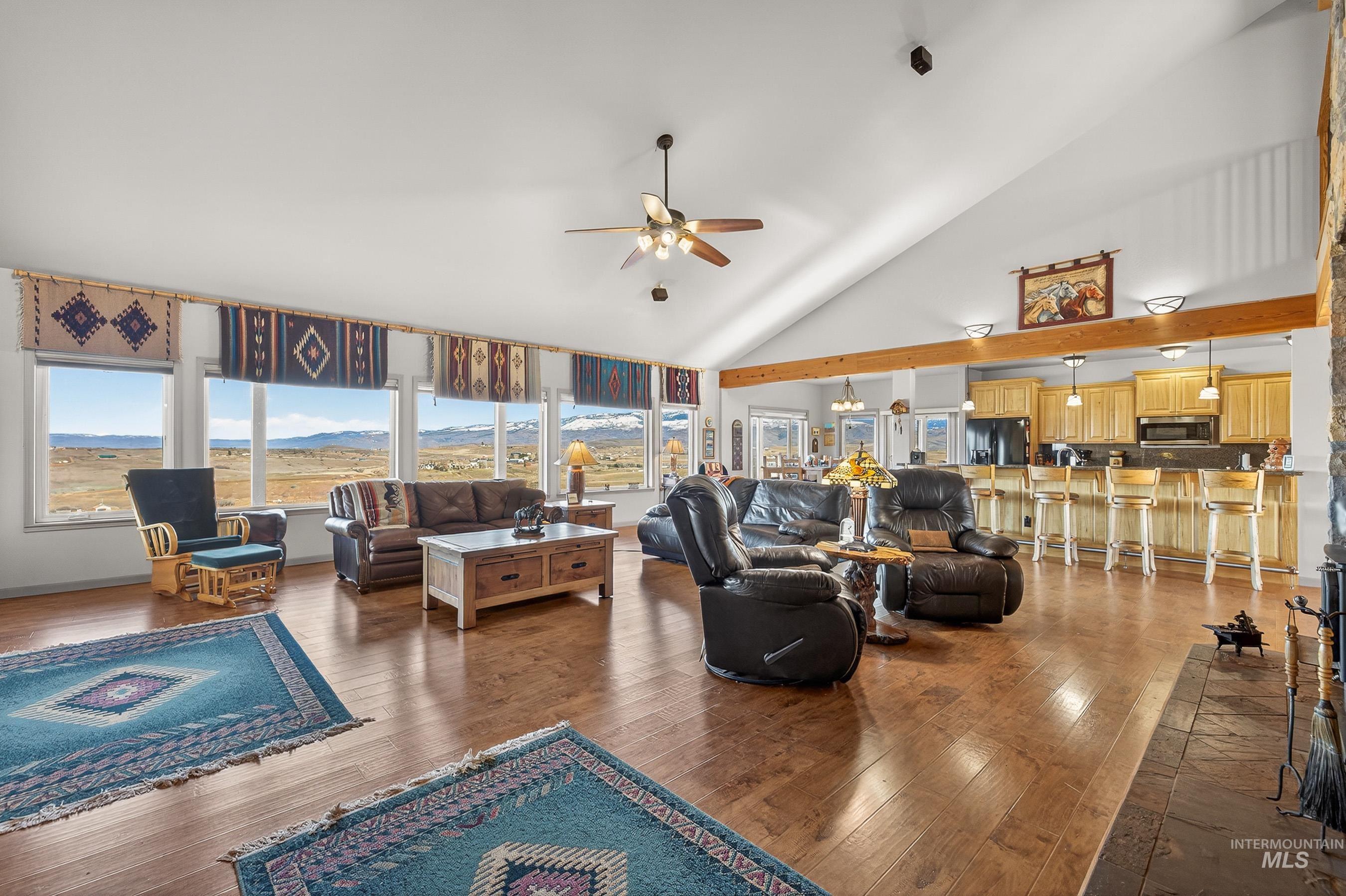 2195 Kilborn Lane Mesa, ID 83643 - Photo 15 of 50 Living room featuring high vaulted ceiling, dark wood-style flooring, a mountain view, and ceiling fan