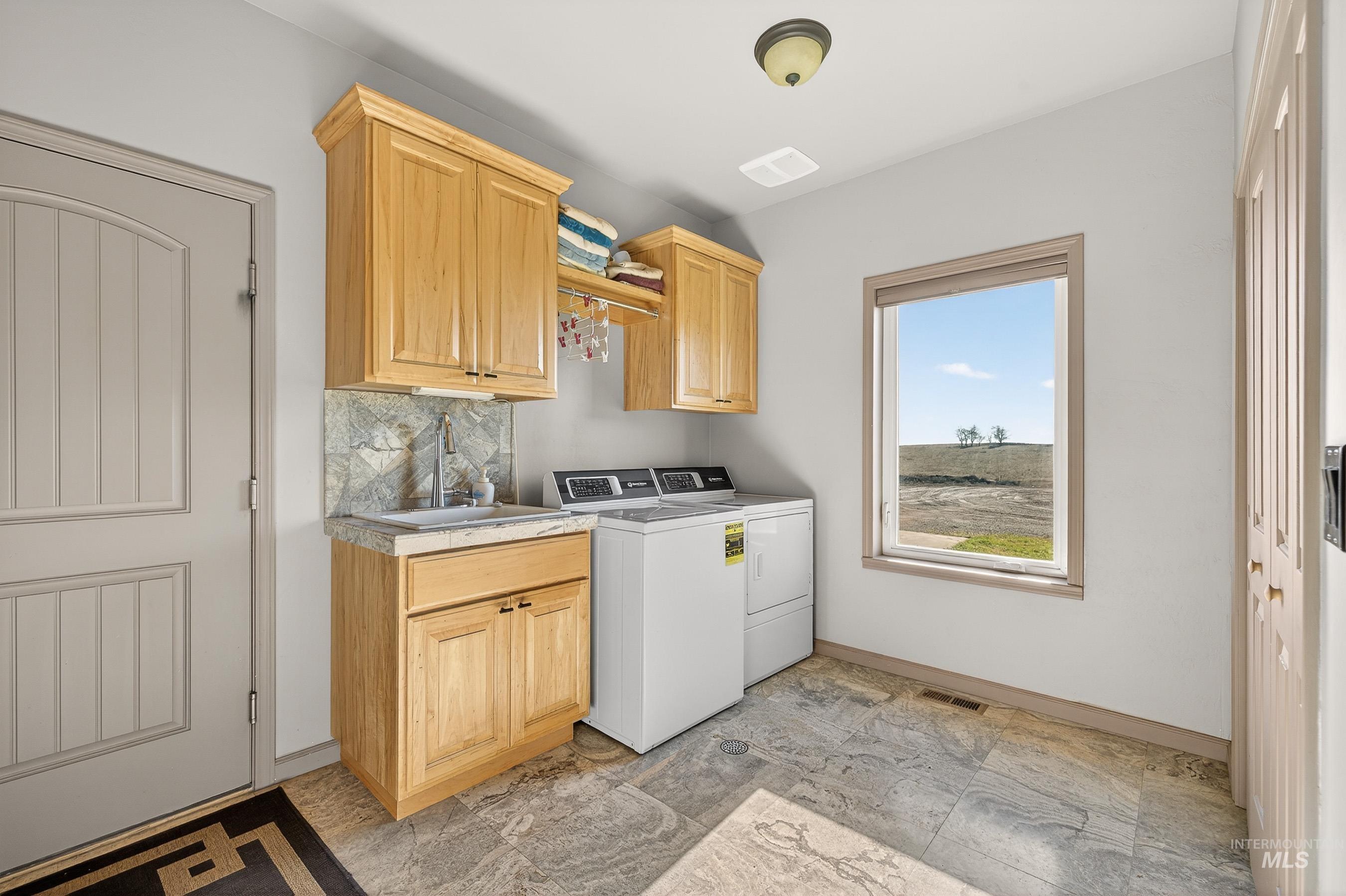 2195 Kilborn Lane Mesa, ID 83643 - Photo 36 of 50 Laundry room with washer and clothes dryer and cabinet space