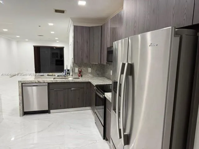 a kitchen with stainless steel appliances a refrigerator stove microwave and sink