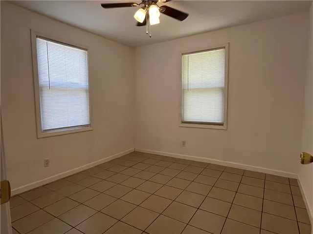 an empty room with chandelier fan