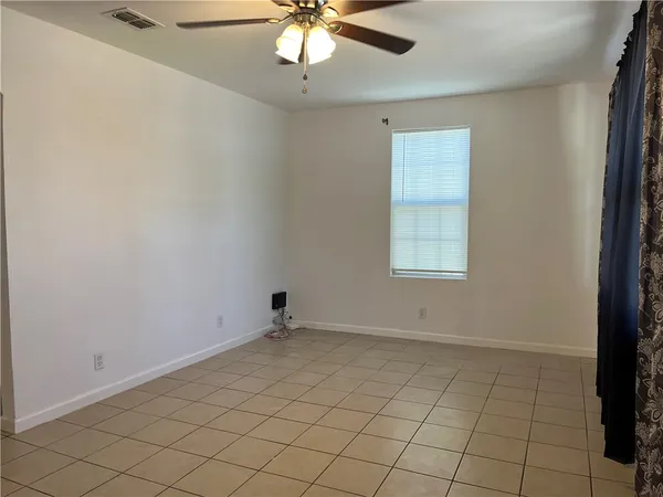 an empty room with chandelier fan