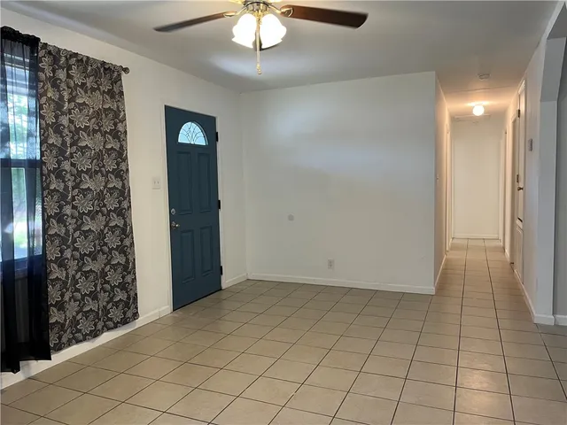 en empty room with wooden floor and chandelier