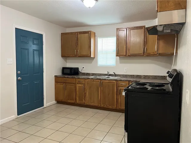 a kitchen with stainless steel appliances granite countertop a refrigerator and a stove