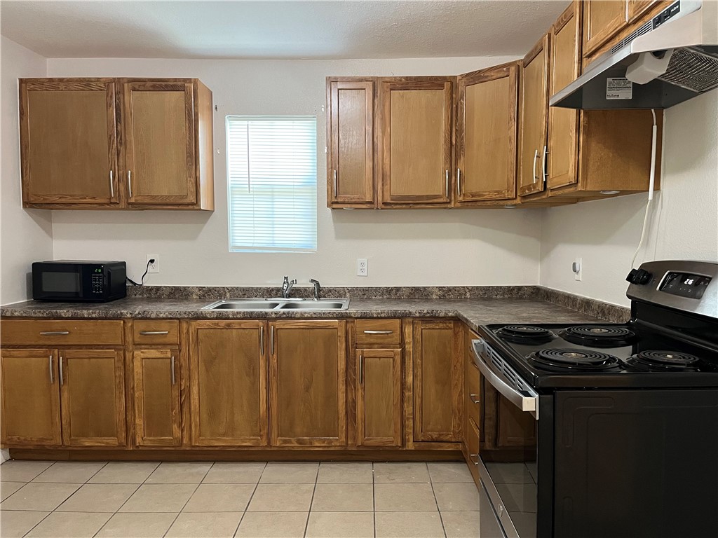 629 Lopez Street Taft, TX 78390 - Photo 7 of 22 a kitchen with stainless steel appliances granite countertop a stove a sink and a microwave