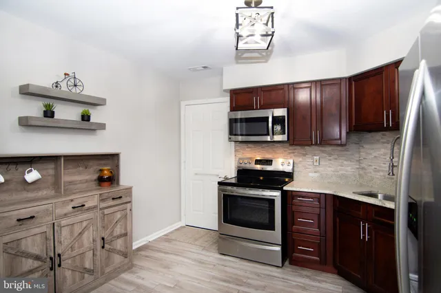 a kitchen with stainless steel appliances granite countertop a stove microwave and sink