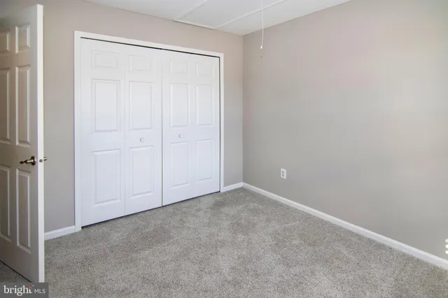 an empty room with windows and closet