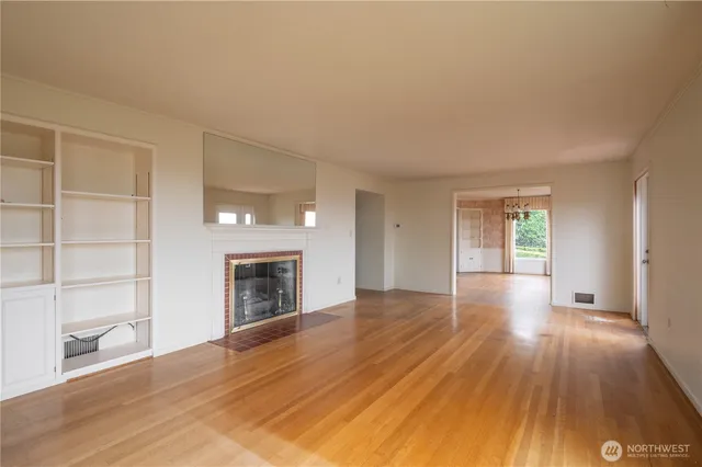 wooden floor fireplace and windows in an empty room