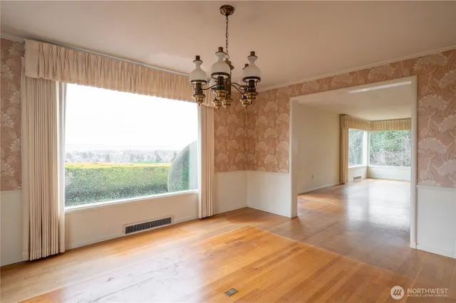 a view of a livingroom with a chandelier wooden floor and a chandelier