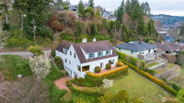 an aerial view of residential houses with outdoor space and trees