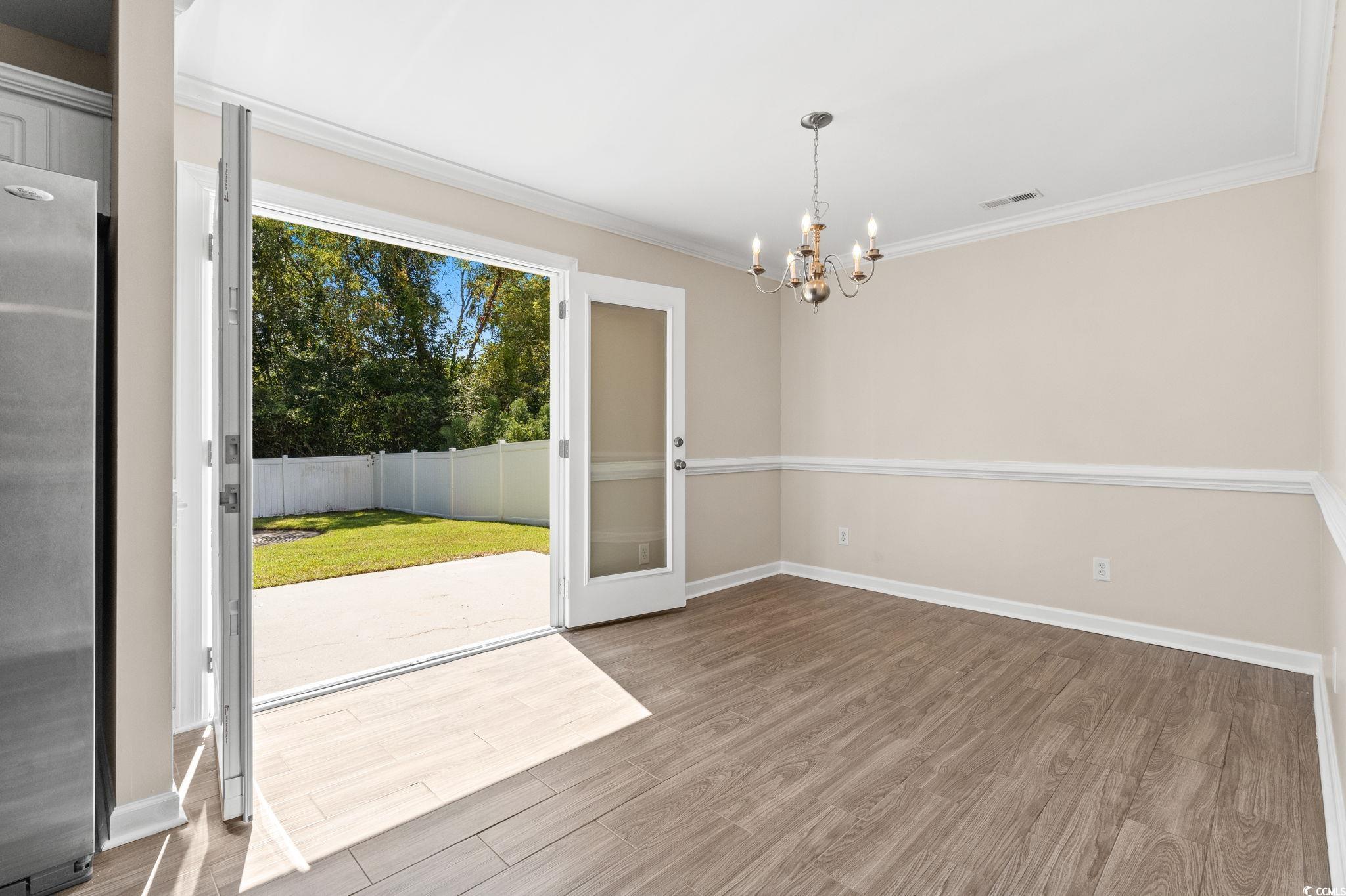 181 Dunbarton Lane Conway, SC 29526 - Photo 12 of 40 Unfurnished dining area featuring wood finished floors, a chandelier, and ornamental molding