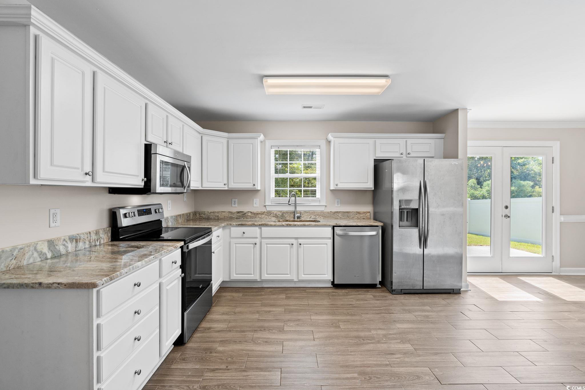 181 Dunbarton Lane Conway, SC 29526 - Photo 13 of 40 Kitchen featuring stainless steel appliances, white cabinetry, french doors, and light wood-style floors