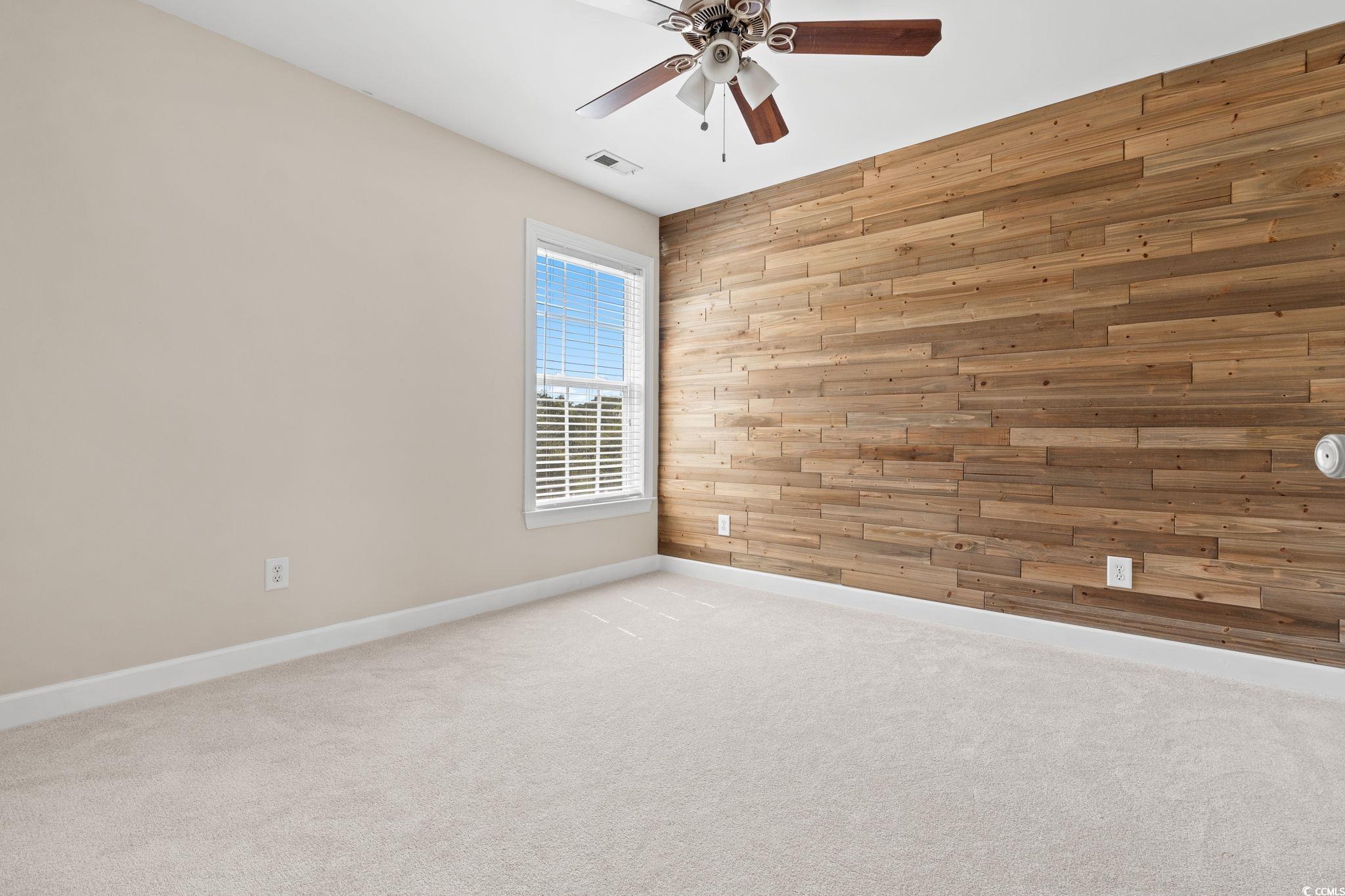 181 Dunbarton Lane Conway, SC 29526 - Photo 31 of 40 Unfurnished room with wood walls, light colored carpet, and a ceiling fan