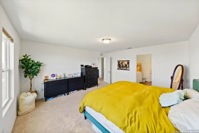 a bedroom with a bed and a potted plant