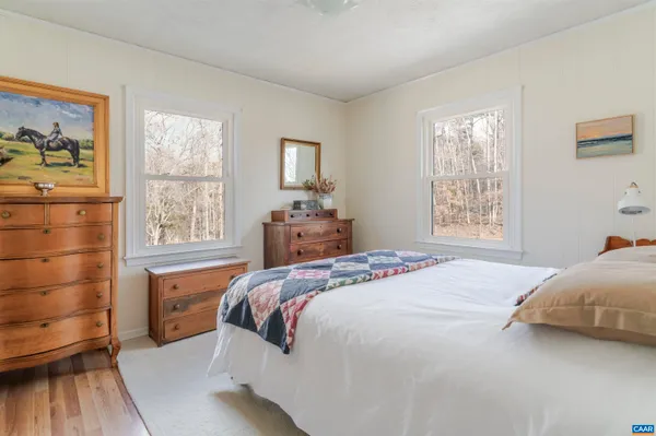 a bedroom with a bed chair and window