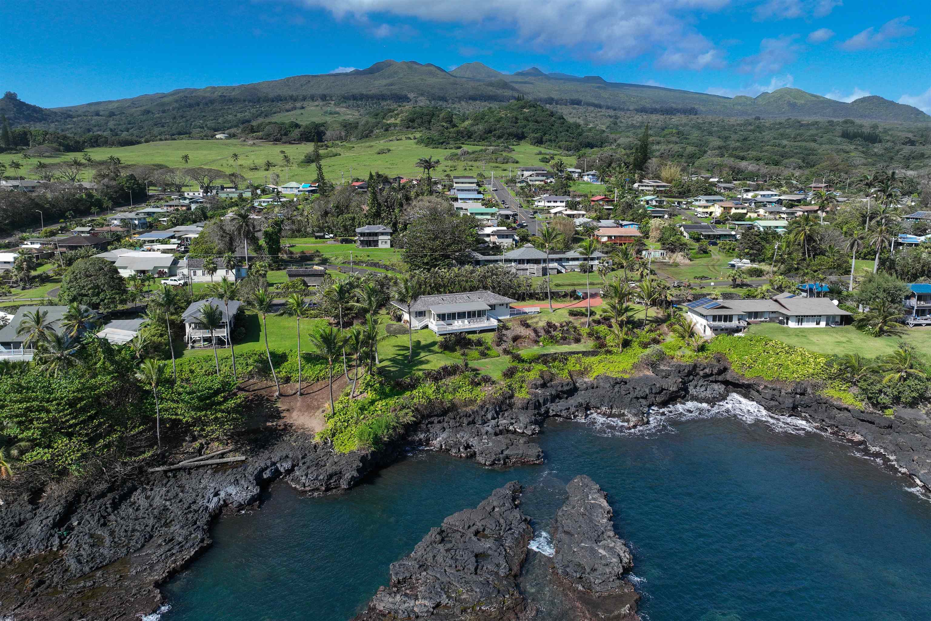 4955 Uakea Road Hana, HI 96713 - Photo 31 of 36 an aerial view of green landscape with trees houses and mountain view