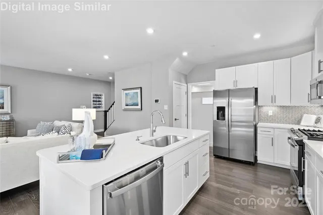 a kitchen with refrigerator and white cabinets