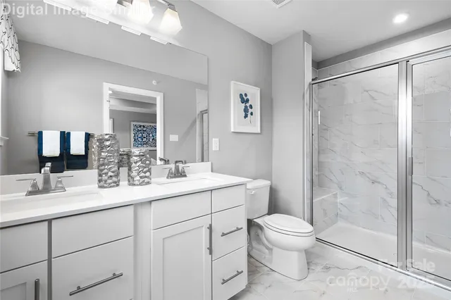 a bathroom with a toilet a sink a mirror a shower a vanity and window