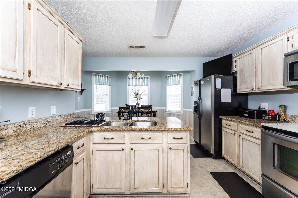 130 Ridge Circle Macon, GA 31216 - Photo 22 of 41 a kitchen with stainless steel appliances granite countertop a sink stove refrigerator and cabinets