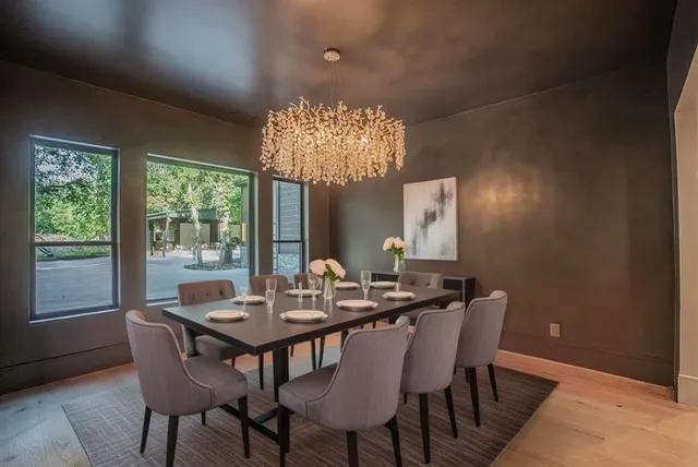 a view of a dining room with furniture a chandelier and wooden floor