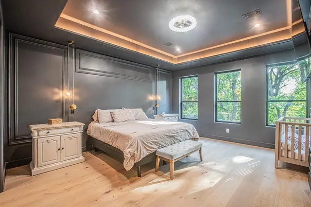 a spacious bedroom with a large bed and a chandelier