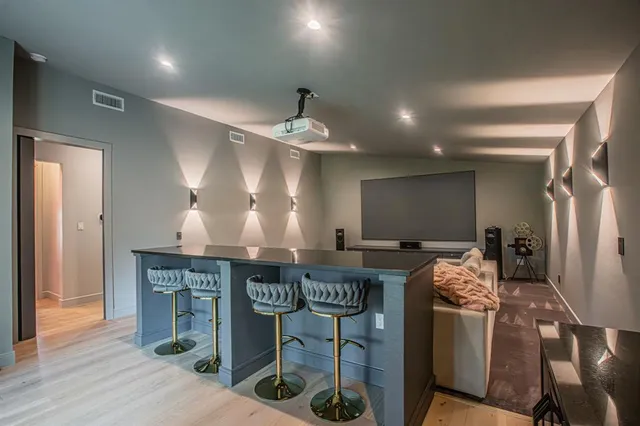 a kitchen with stainless steel appliances granite countertop a stove a sink dishwasher and a refrigerator with wooden floor