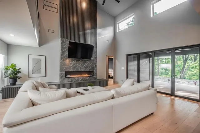 a living room with furniture a large window and a flat screen tv