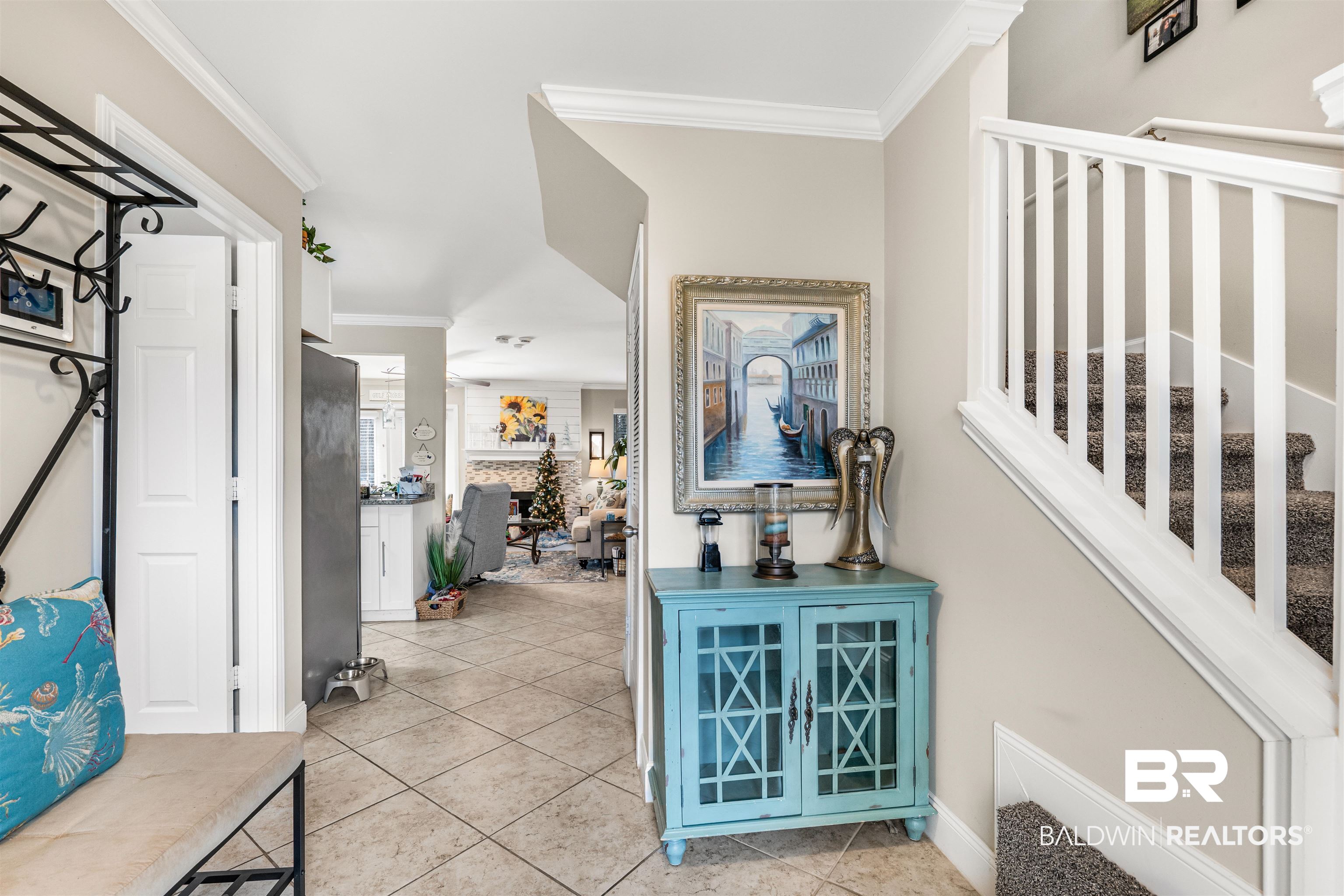1517 Regency Road, Unit 68 Gulf Shores, AL 36542 - Photo 4 of 43 Bar featuring stainless steel refrigerator, a fireplace, light tile patterned floors, and ornamental molding