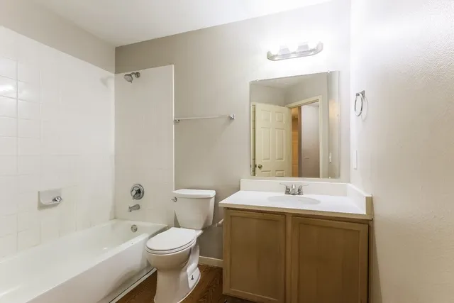 a bathroom with a sink toilet vanity and shower