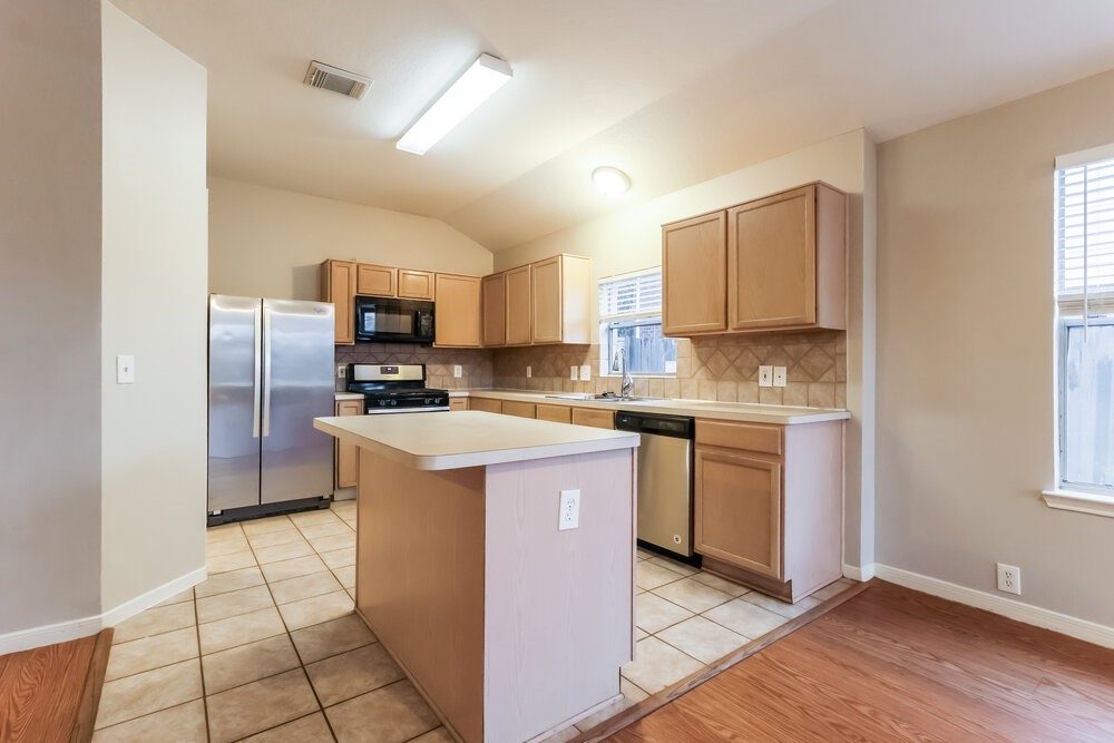 614 Cypresswood Trace Spring, TX 77373 - Photo 6 of 16 a kitchen with a sink a counter top space cabinets and stainless steel appliances