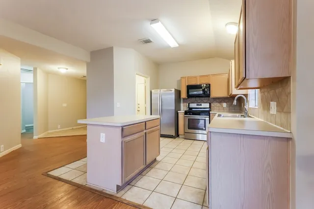 a kitchen with stainless steel appliances granite countertop a stove top oven a sink and dishwasher