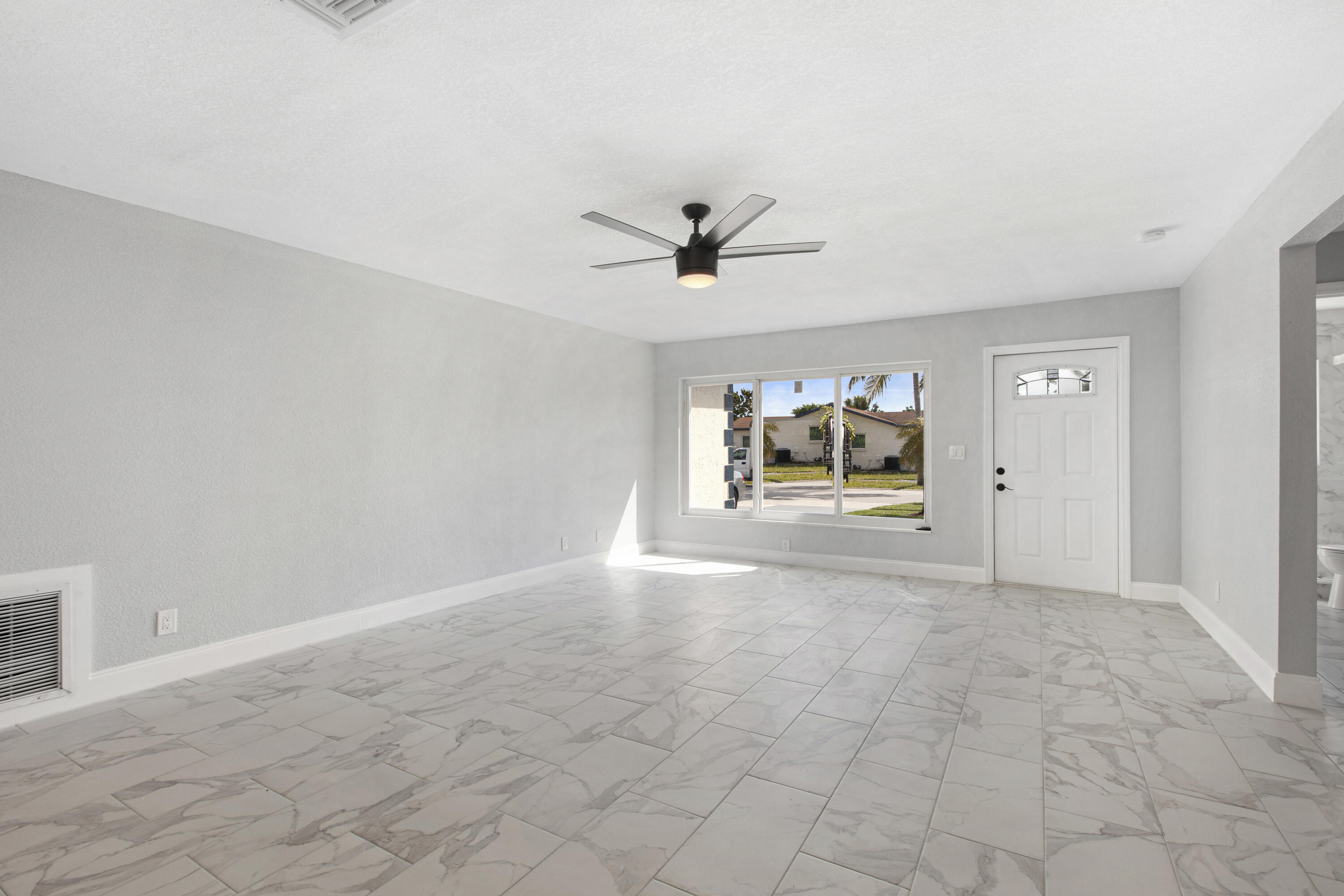 22848 Southwest 54th Way Boca Raton, FL 33433 - Photo 4 of 20 an empty room with chandelier fan and windows