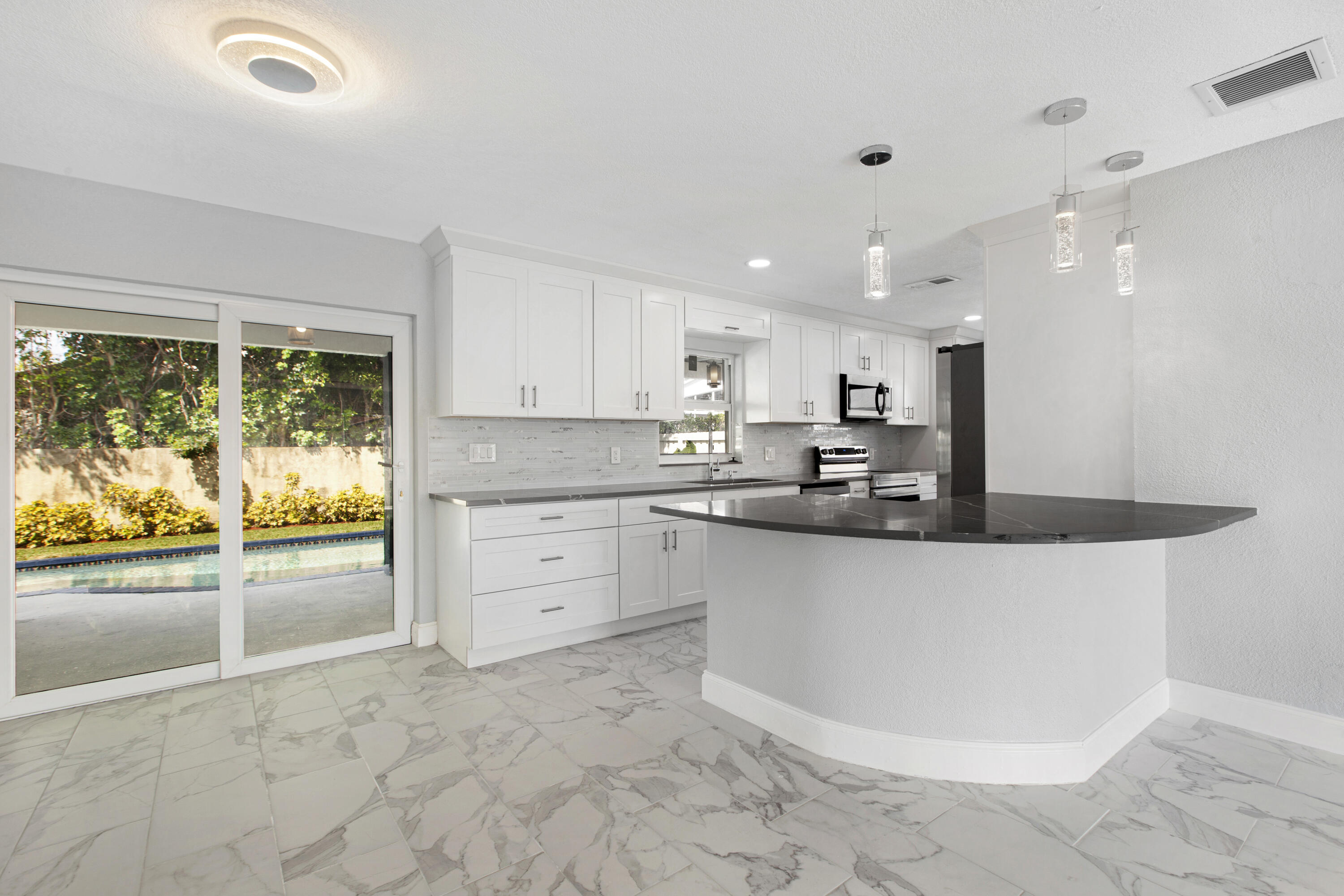 22848 Southwest 54th Way Boca Raton, FL 33433 - Photo 6 of 20 a large kitchen with stainless steel appliances granite countertop a stove a sink and a refrigerator