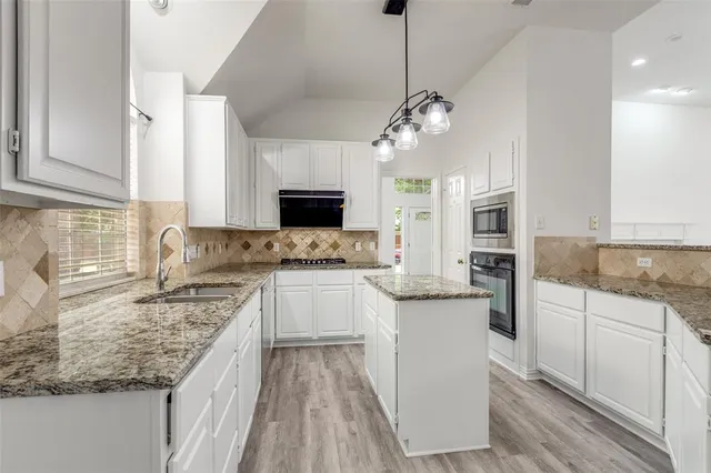 a kitchen with a center island appliances and cabinets