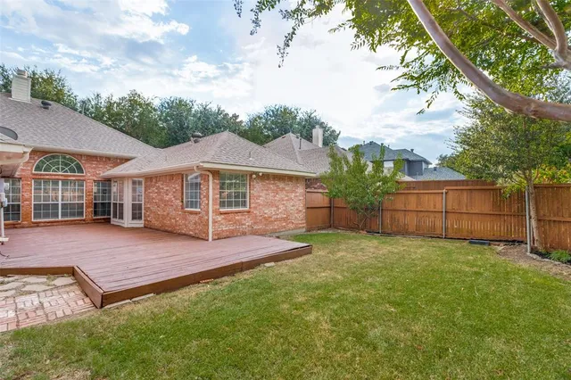a view of a yard in front of a house with large tree