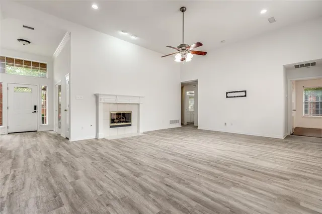 a view of empty room with wooden floor and ceiling fan