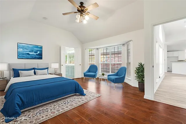 a bedroom with a large bed a rug and wooden floor