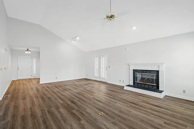 a view of empty room with wooden floor and fireplace