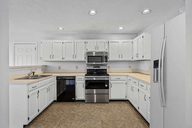 a kitchen with cabinets appliances and a sink