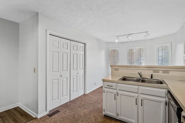 a kitchen with white cabinets and sink
