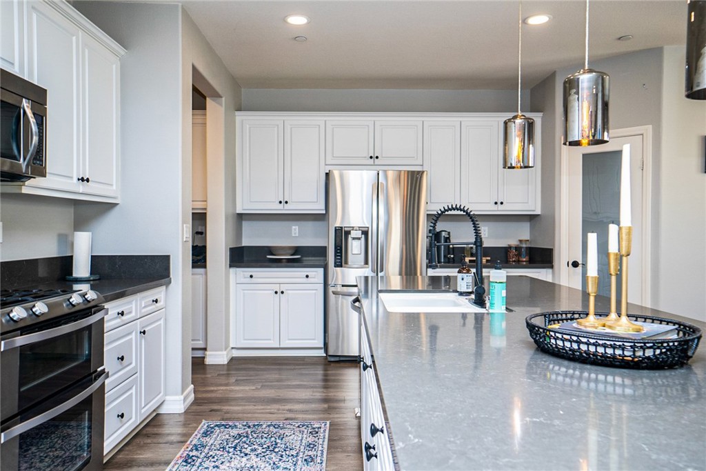 4788 Condor Avenue Fontana, CA 92336 - Photo 13 of 49 a kitchen with stainless steel appliances granite countertop a stove a refrigerator a sink a stove and white cabinets
