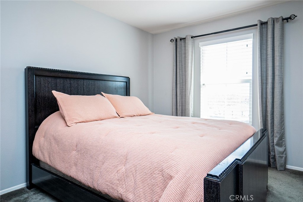 4788 Condor Avenue Fontana, CA 92336 - Photo 21 of 49 a large bed sitting in a bedroom next to a window