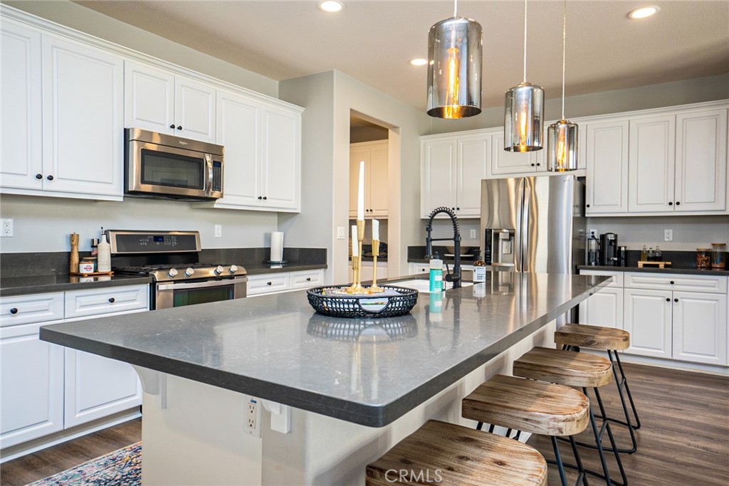 4788 Condor Avenue Fontana, CA 92336 - Photo 6 of 49 a kitchen with stainless steel appliances a dining table and chairs