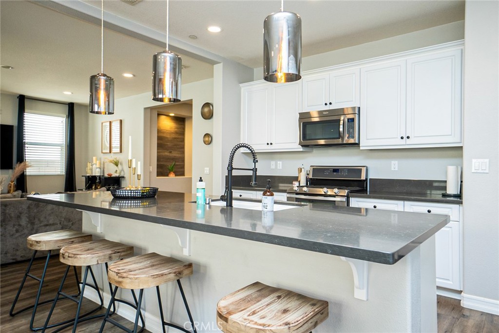 4788 Condor Avenue Fontana, CA 92336 - Photo 8 of 49 a kitchen with stainless steel appliances granite countertop a sink a stove and a microwave