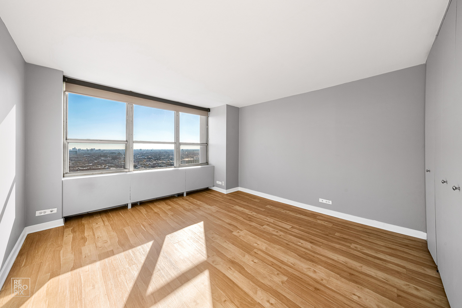 655 West Irving Park Road, Unit 3717 Chicago, IL 60613 - Photo 9 of 22 a view of an empty room with wooden floor and a window