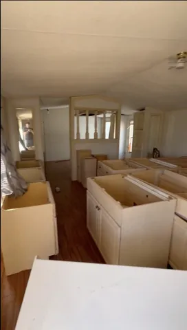 a living room with stainless steel appliances kitchen island granite countertop a sink a stove and a window