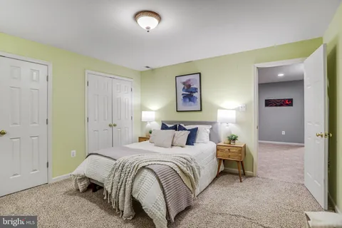 a spacious bedroom with a bed and painting on the wall