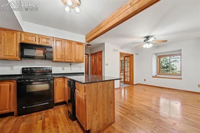 a kitchen with stainless steel appliances granite countertop a stove a sink dishwasher and a microwave oven with cabinets