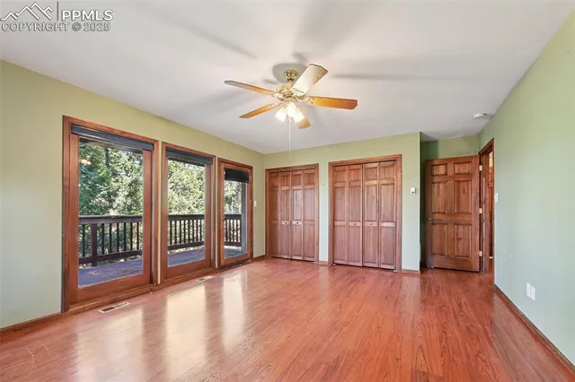 a view of n empty room with window and a ceiling fan