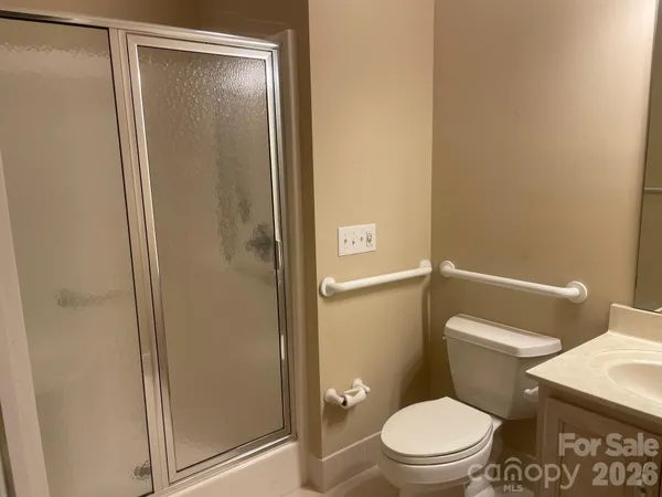 a white toilet sitting next to a shower